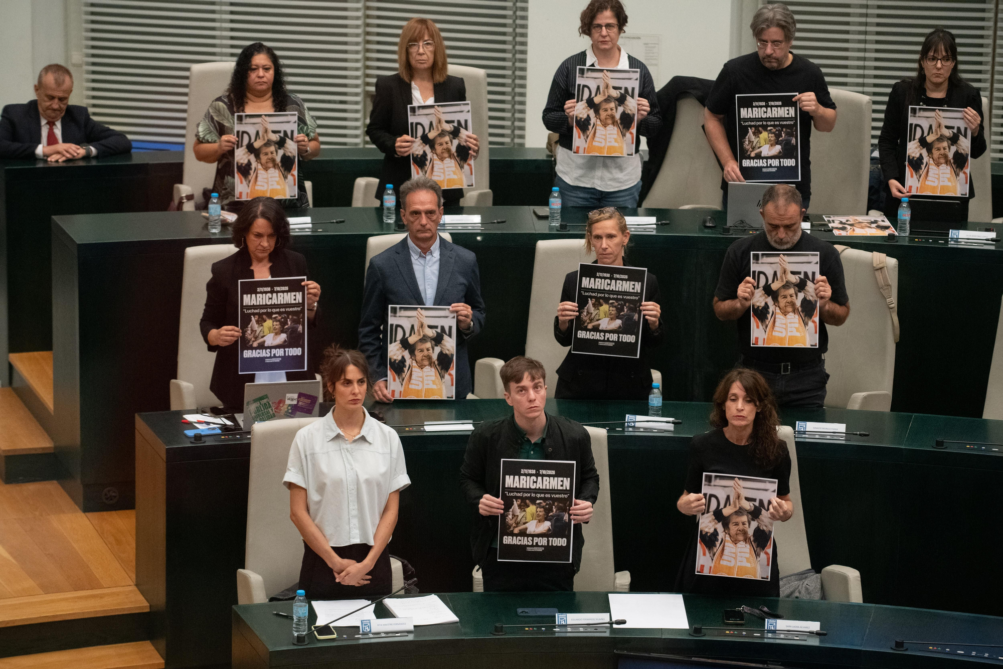 Concejales de Más Madrid muestran carteles con la imagen de Maricarmen en el pleno del Ayuntamiento.