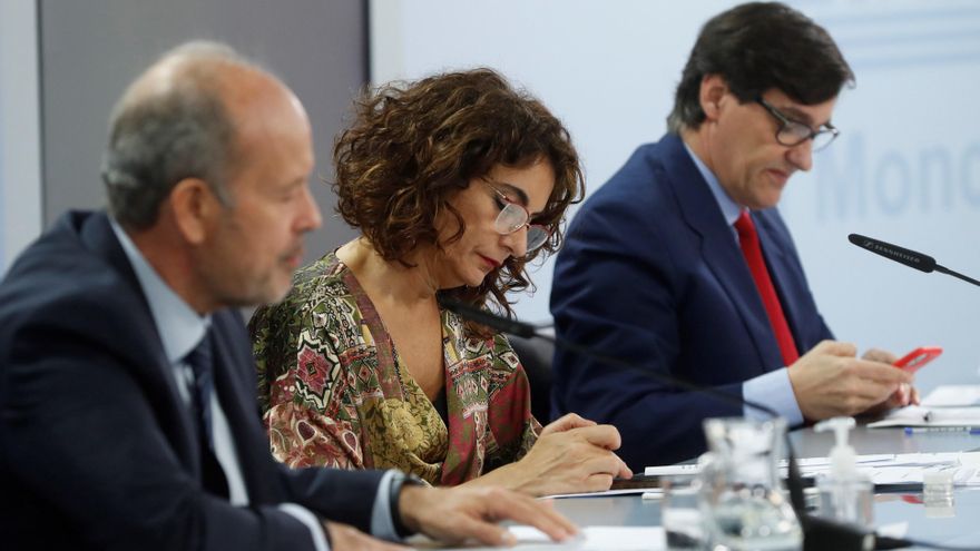 La ministra portavoz, María Jesús Montero (c), el ministro de Sanidad, Salvador Illa (d), y el ministro de Justicia, Juan Carlos Campo, comparecen en la rueda de prensa posterior al Consejo de Ministros. EFE/ J.J. Guillén
