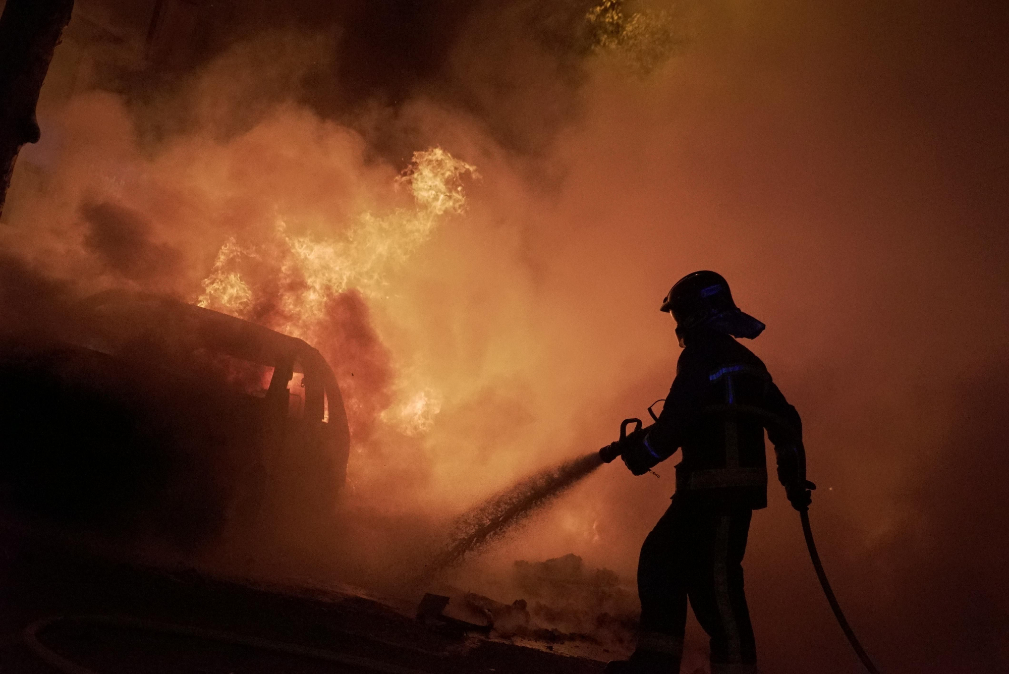 Un bombero apaga el fuego de las barricadas en el tercer día de protestas en Barcelona