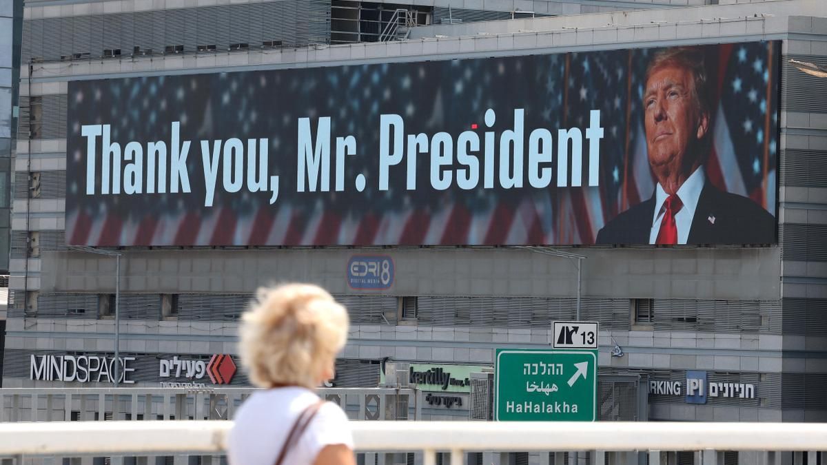 Una mujer pasea este domingo frente al cartel desplegado en Tel Aviv en honor a Donald Trump