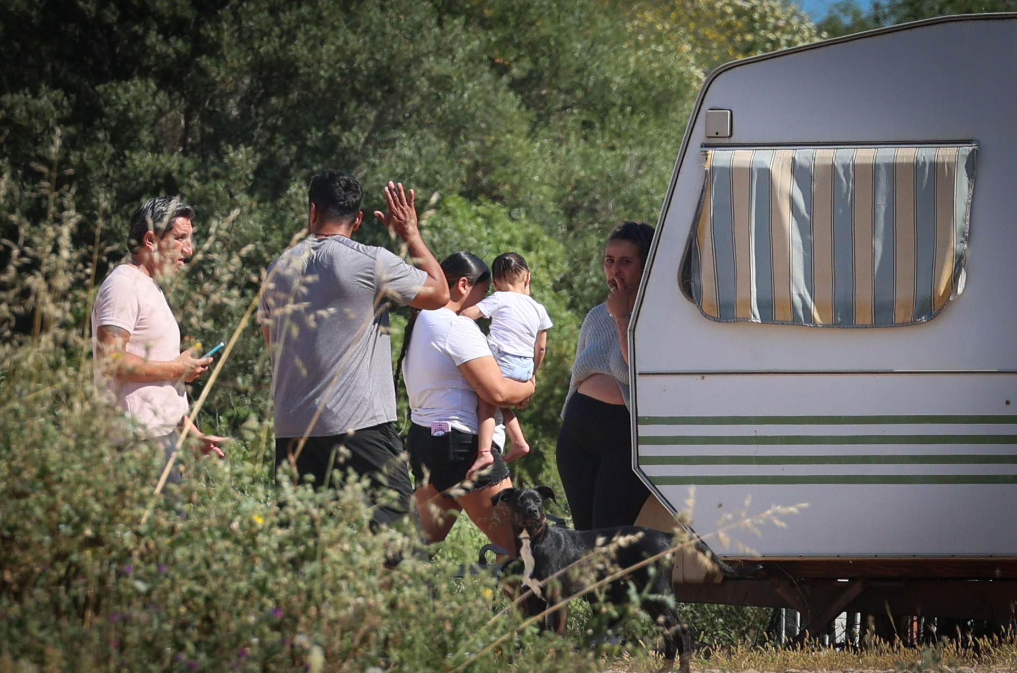 Diverses persones recullen les seves pertinences al costat d'una caravana després de ser desallotjades de l'assentament.