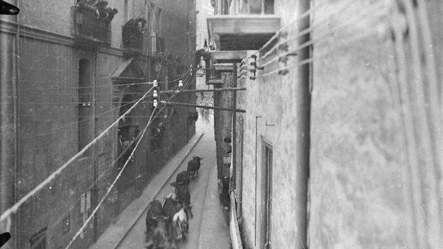 Vista de la calle Santo Domingo a la altura del Ayuntamiento antes de la reforma de 1952 durante un encierro, donde se puede ver la puerta barroca.