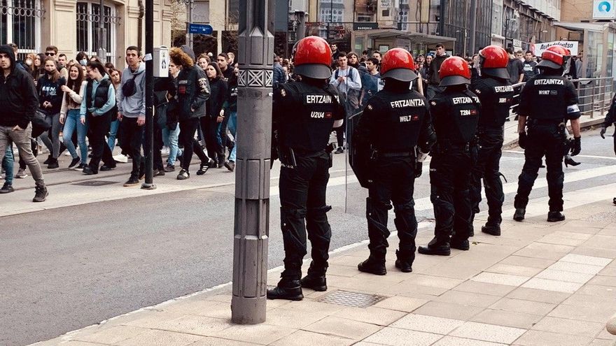 Varios manifestantes marchan junto al Parlamento Vasco, vigilados de cerca por la Ertzaintza