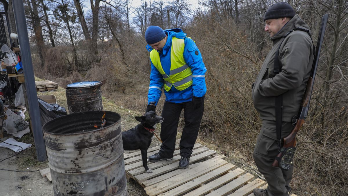 Un hombre armado y otro con su perro en un control de seguridad de residentes de Lviv, el 8 de marzo