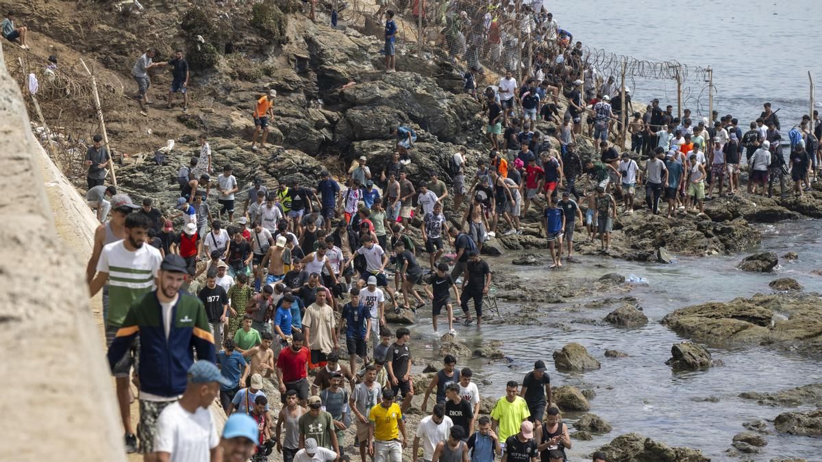 Migrantes cruzando la frontera en Ceuta en dirección a Marruecos.