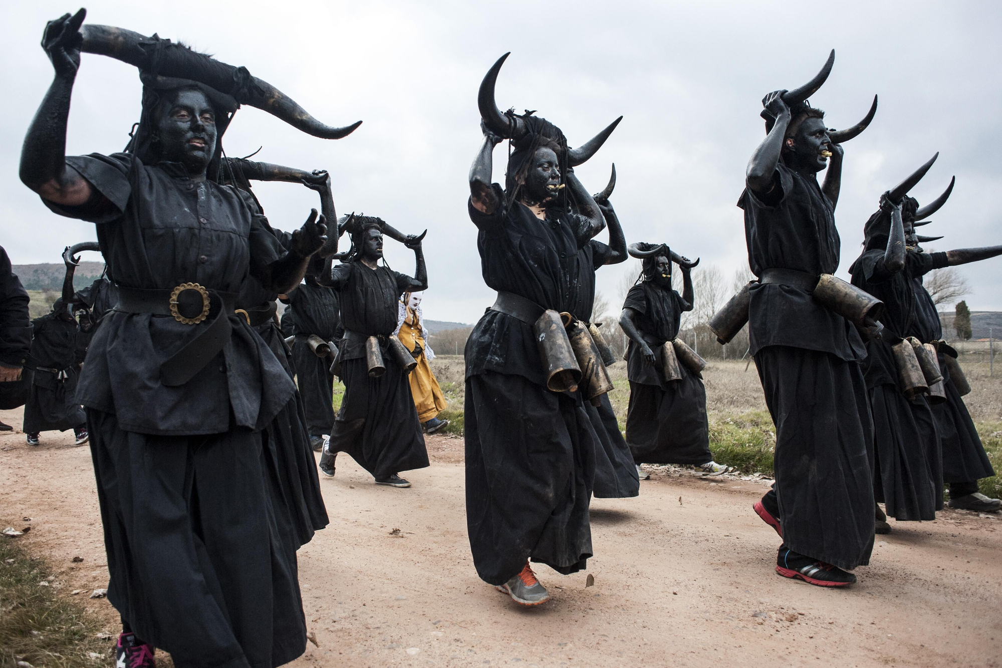 Los 'diablos' pintados de negro y agitando sus cencerros se dirigen al pueblo de Luzón (Guadalajara). Joaquín Gómez Sastre