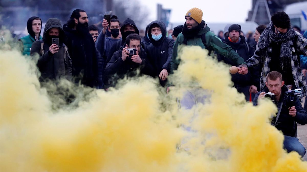 Protesters take pictures of the yellow smoke form a flare during clashes on the sidelines of a protest against European anti-coronavirus measures, in Brussels, Belgium, 23 January 2022. Tens of thousands of people were expected to a protest against the way the EU governments imposed 'disproportionate measures that violate human rights', as organiser 'Europeans United' puts it, to curb the Omicron variant wave of the Sars-Cov-2 coronavirus. (Protestas, Bélgica, Estados Unidos, Bruselas)