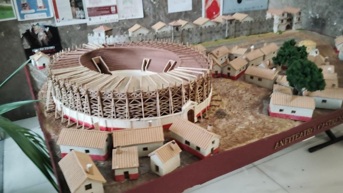 Imagen borrosa de P¡prueba para mejorar con IA de la maqueta del anfiteatro castrense legionario de Castra Legio (León); la calidad es bastante mala y se puede comprobar la mejora en la fotografía que abre este reportaje y cómo se han eliminado los carteles y cambiado el lema de la mesa. La estrella blanca de cuatro puntas que se ve en la imagen principal del reportaje es la marca de agua de firma de la IA de Google.