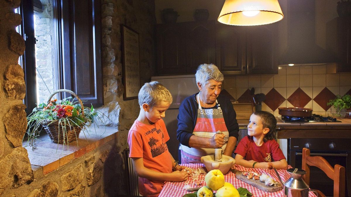 Una àvia amb els néts, preparant un all i oli de condony