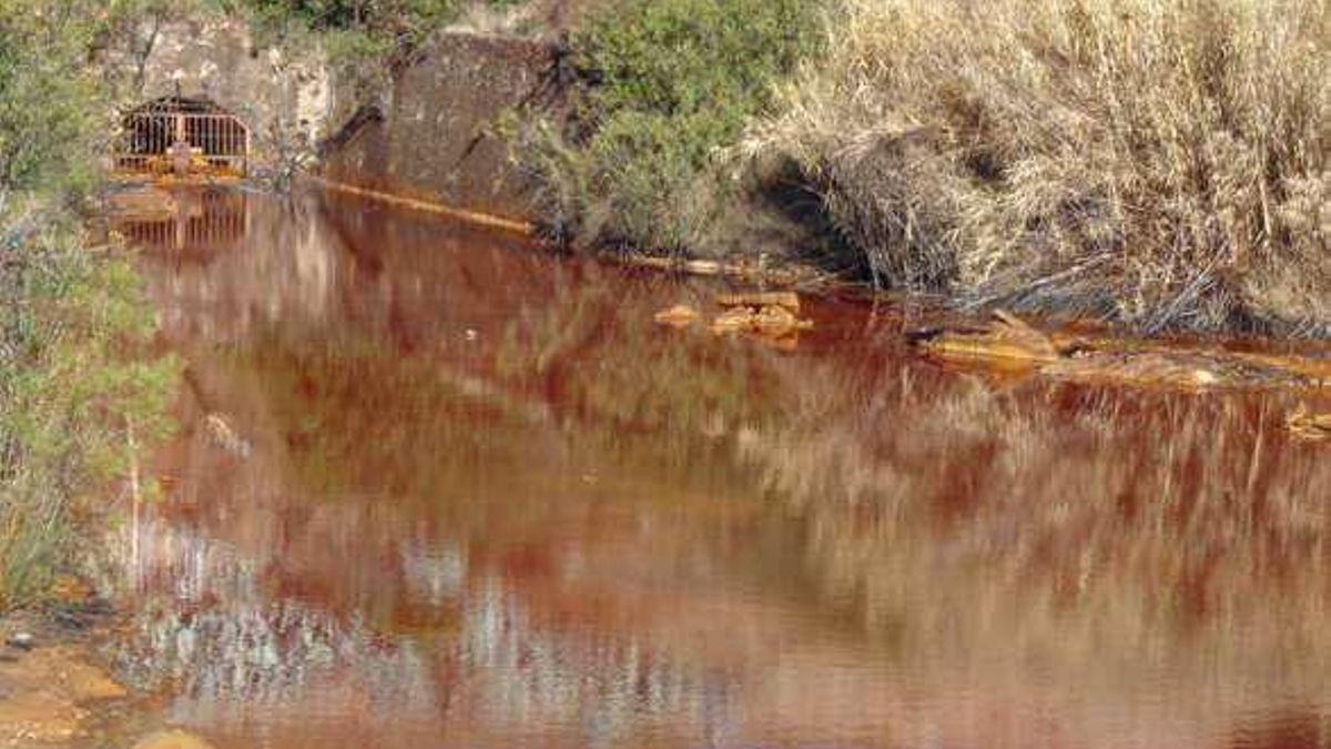 Salida de aguas ácidas de un viejo túnel minero en dirección al río Tinto.
