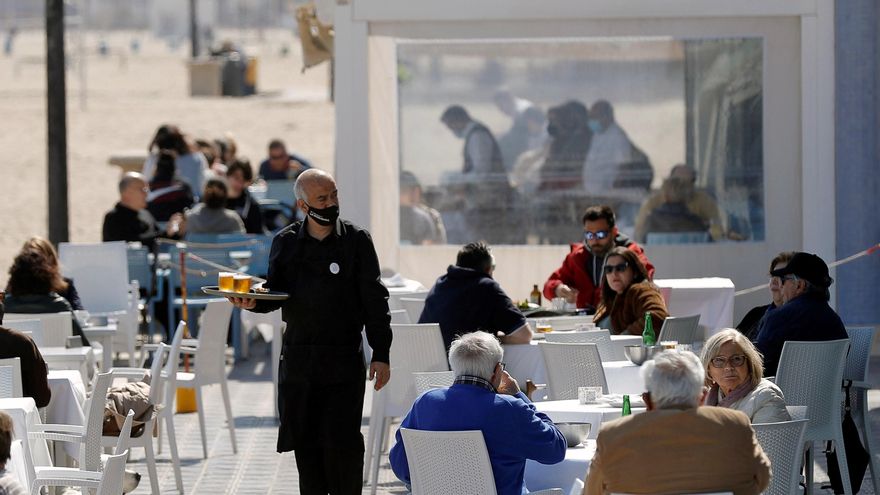 Un camarero atiende las mesas de una terraza en uno de los restaurantes de la playa de la Malvarrosa de Valéncia. EFE/Manuel Bruque/Archivo