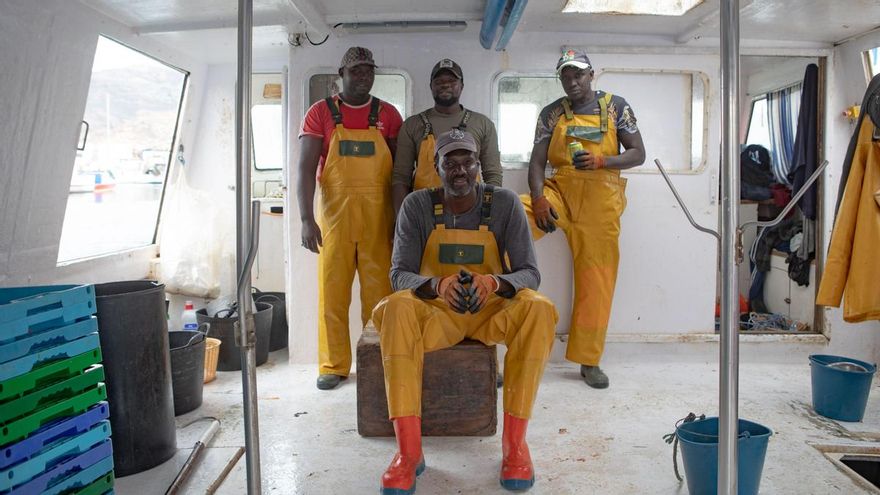 Baye Diagne, sentado, y Elhadji Madiop, Idrissa Diagne y Seck Ngagne, de izquierda a derecha, cuatro pescadores senegaleses que abandonaron su país en la diáspora de 2006, posan en un pesquero del puerto de Cartagena.