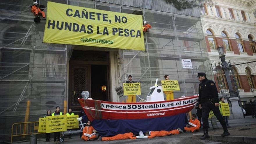 Miembros de Greenpeace se encadenan a un barco para protestar por la política pesquera