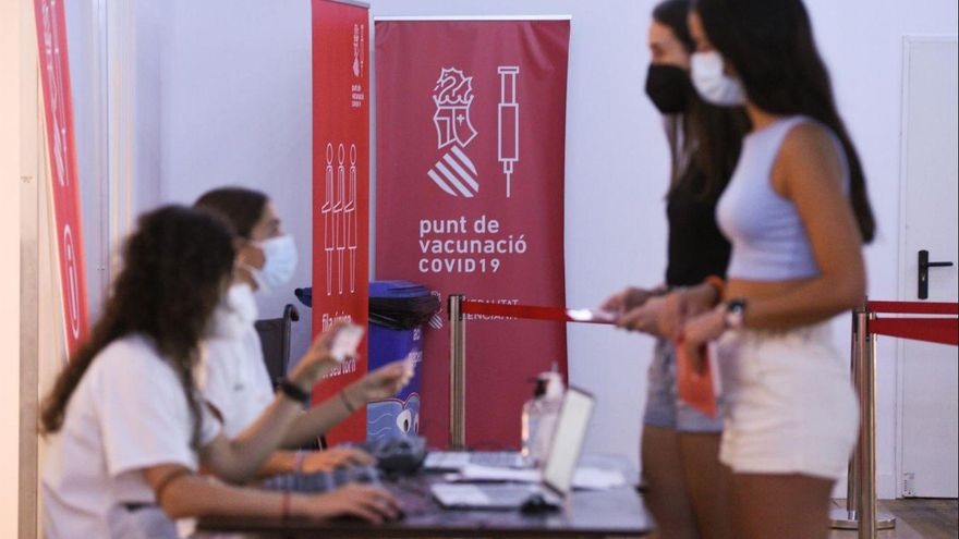 Dos adolecentes en el registro, después de recibir la primera dosis de la vacuna Pfizer en el punto de vacunación de Xátiva, situado en el Hogar de los Jubilados.