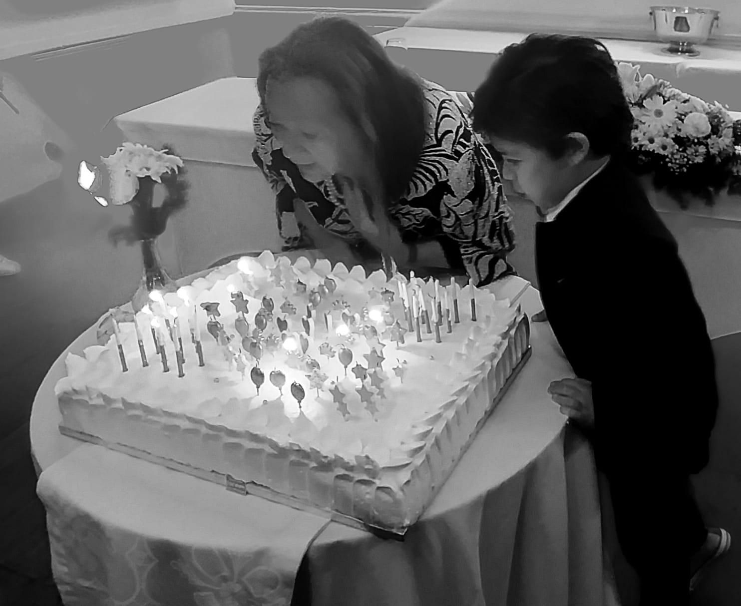 Elsa López y su nieto Marcelo apagando las velas de la tarta. JORGE LOZANO