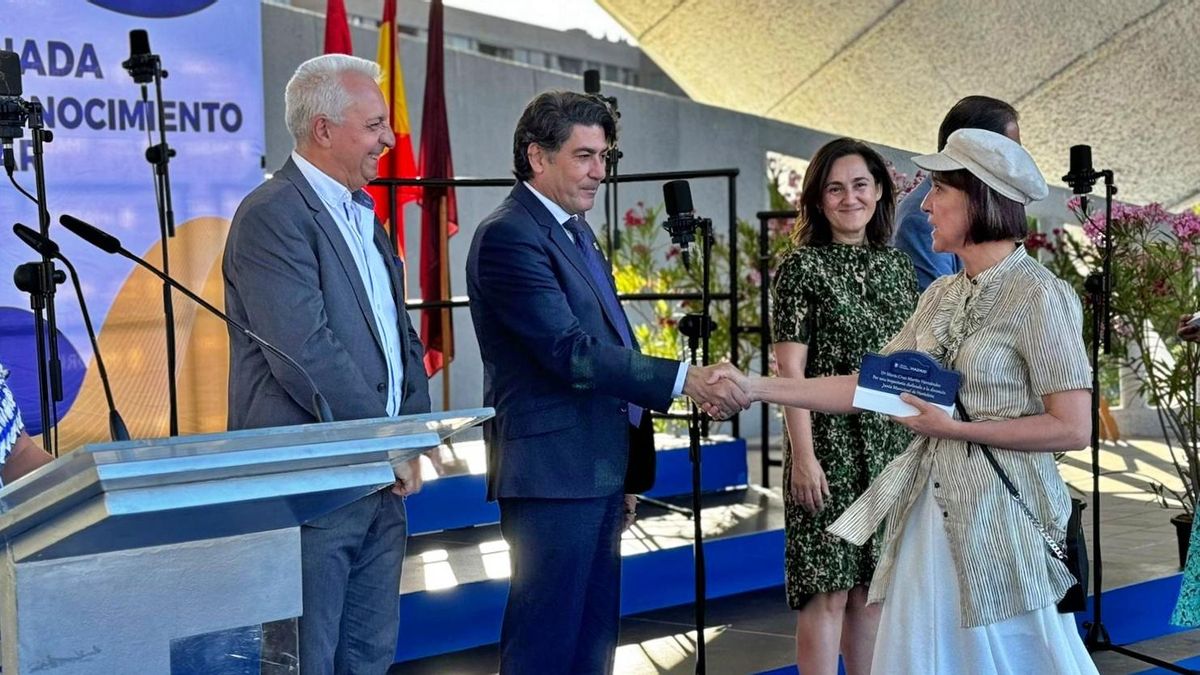 El concejal de Hortaleza, David Pérez, estrecha la mano a una de las docentes reconocidas en los premios de excelencia académica del distrito de 2024, celebrados en el auditorio Pilar García Peña.