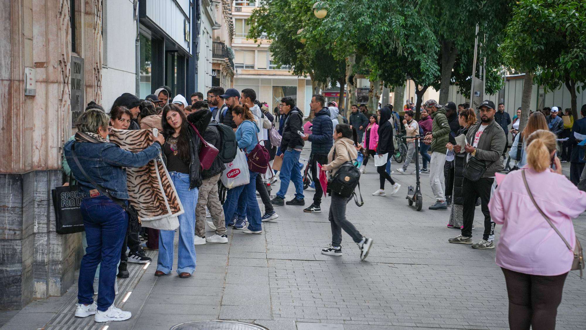 Largas colas de personas migrantes durante la atención presencial para su regularización