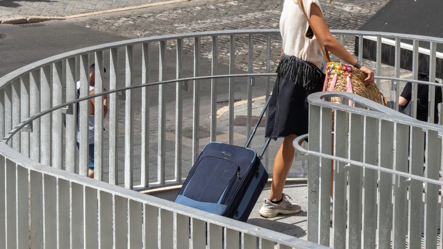 Una joven turista con maletas en el entorno de las Setas de la Encarnación, en  Sevilla a 3 de agosto del 2020