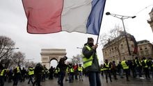 Un manifestante de los chalecos amarillos ondea una bandera francesa durante una protesta en París
