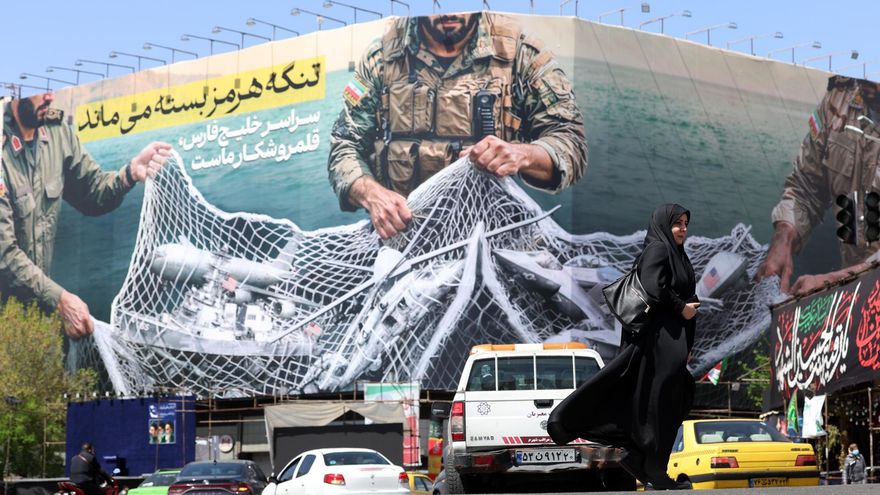Una mujer pasa junto a una valla con el mensaje "El estrecho de Ormuz permanecerá cerrado" en la plaza Enghelb de Teherán, 5 de abril de 2026.