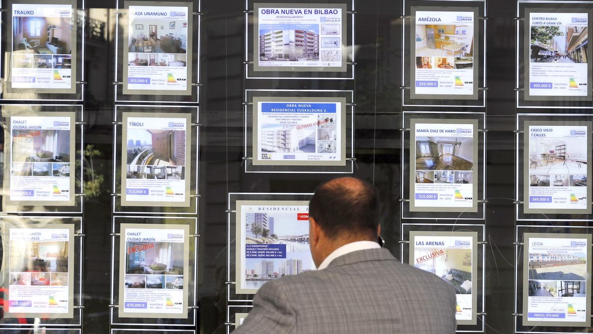 Un hombre observa un escaparate de una inmobiliaria.