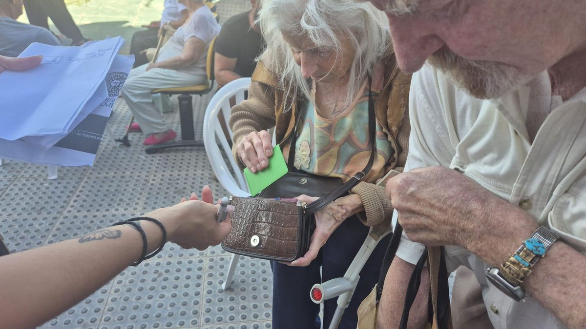Jochen e Ingrid, de Karlsruhe, muestran su documentación en la puerta del polideportivo Vista Alegra de Garrucha para ser trasladados a un hotel