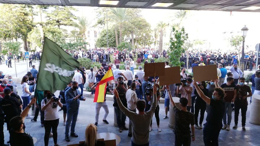 Seguidores de Vox levantan pancartas momentos antes del acto de Abascal en Ceuta
