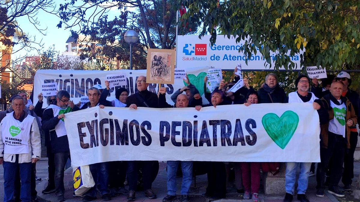 Varias personas sujetan las pancartas que reclaman más pediatras junto a la sede de la Gerencia de Atención Primaria
