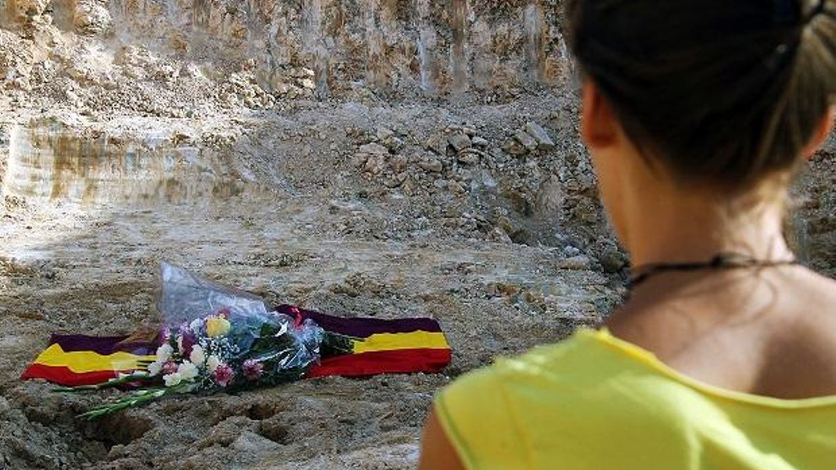 Una mujer, la tierra abierta, una fosa común.