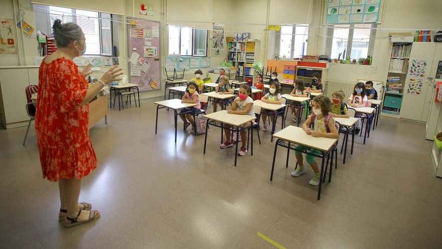 Una maestra se dirige a los alumnos, todos con mascarilla, en el primer día de clase en el colegio Balmes de València.