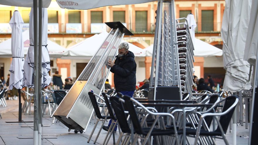 Un trabajador recoge el mobiliario de la terraza de un restaurante en el centro de Córdoba, este lunes. EFE/Salas