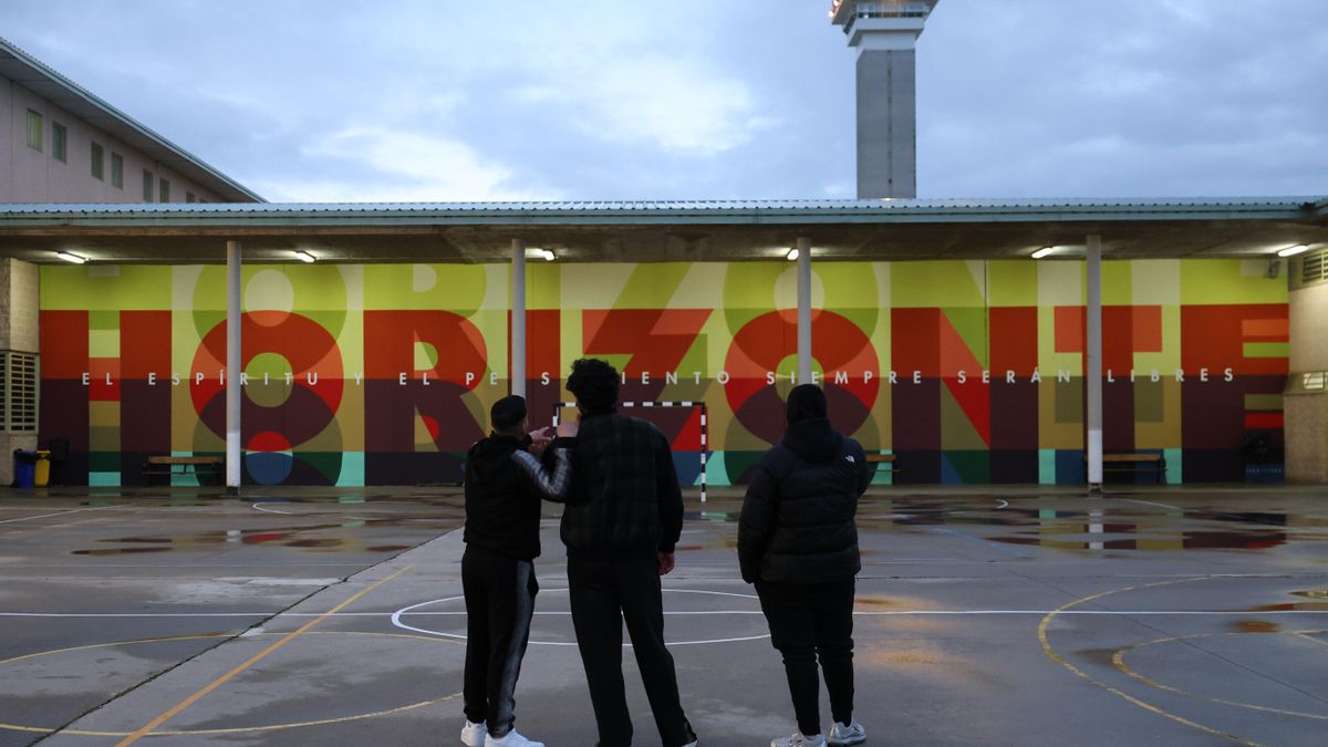 Tres de los internos de Soto del Real frente al mural pintado por Boa Mistura.