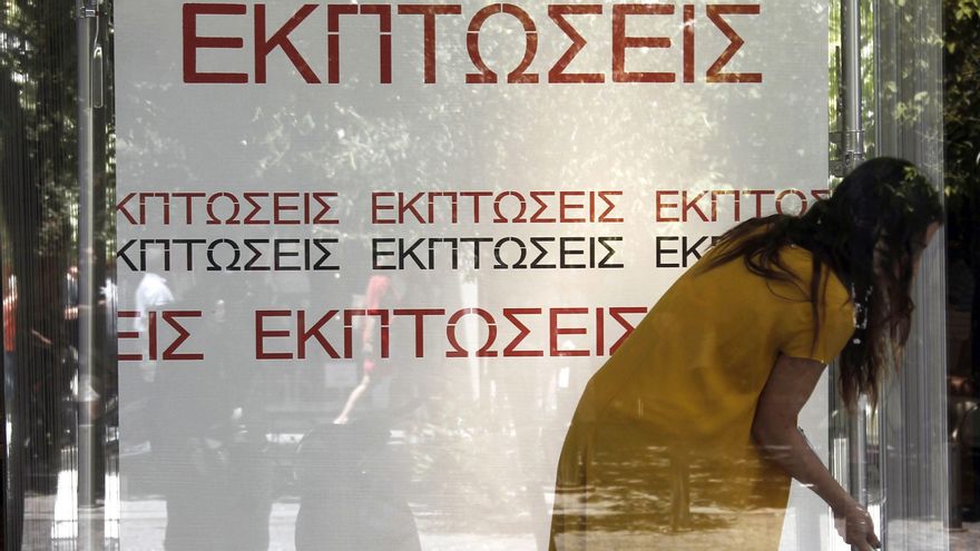 Una mujer limpia una tienda en Atenas. EPA/ALEXANDROS VLACHOS/Archivo