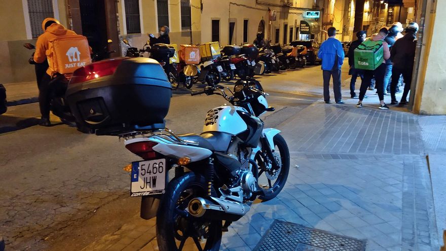 Repartidores esperan su turno en la cocina fantasma de la calle José Calvo