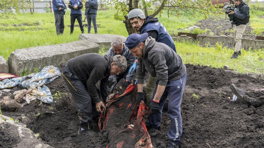 Expertos policiales exhumaban el cuerpo de un civil hallado en el jardín de una vivienda en el área de Járkov, Ucrania, el pasado mes de mayo