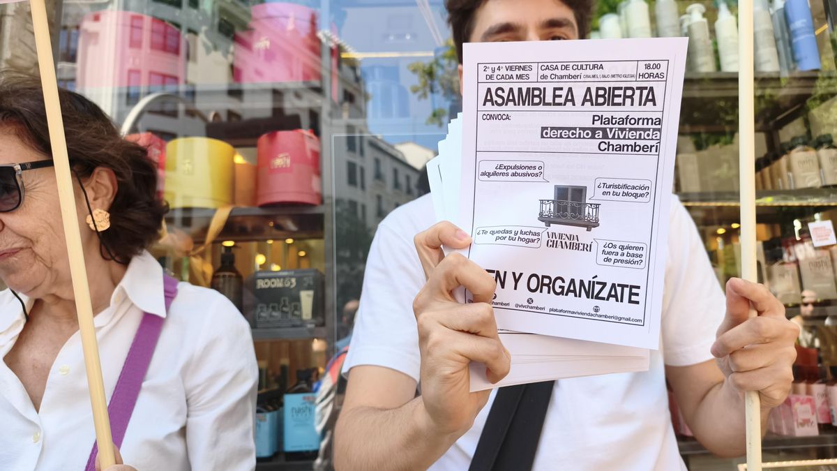 Un joven sujeta un papel que convoca a una asamblea por el derecho a la Vivienda durante la manifestación de inquilinos en Génova