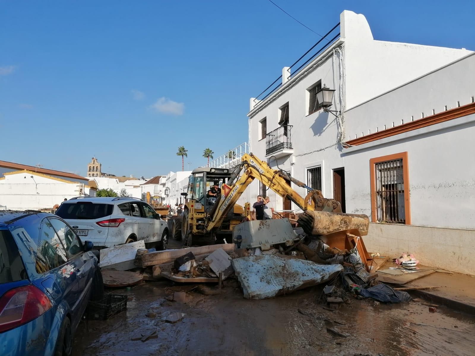 Una excavadora retirando enseres inservibles en una calle de Lepe