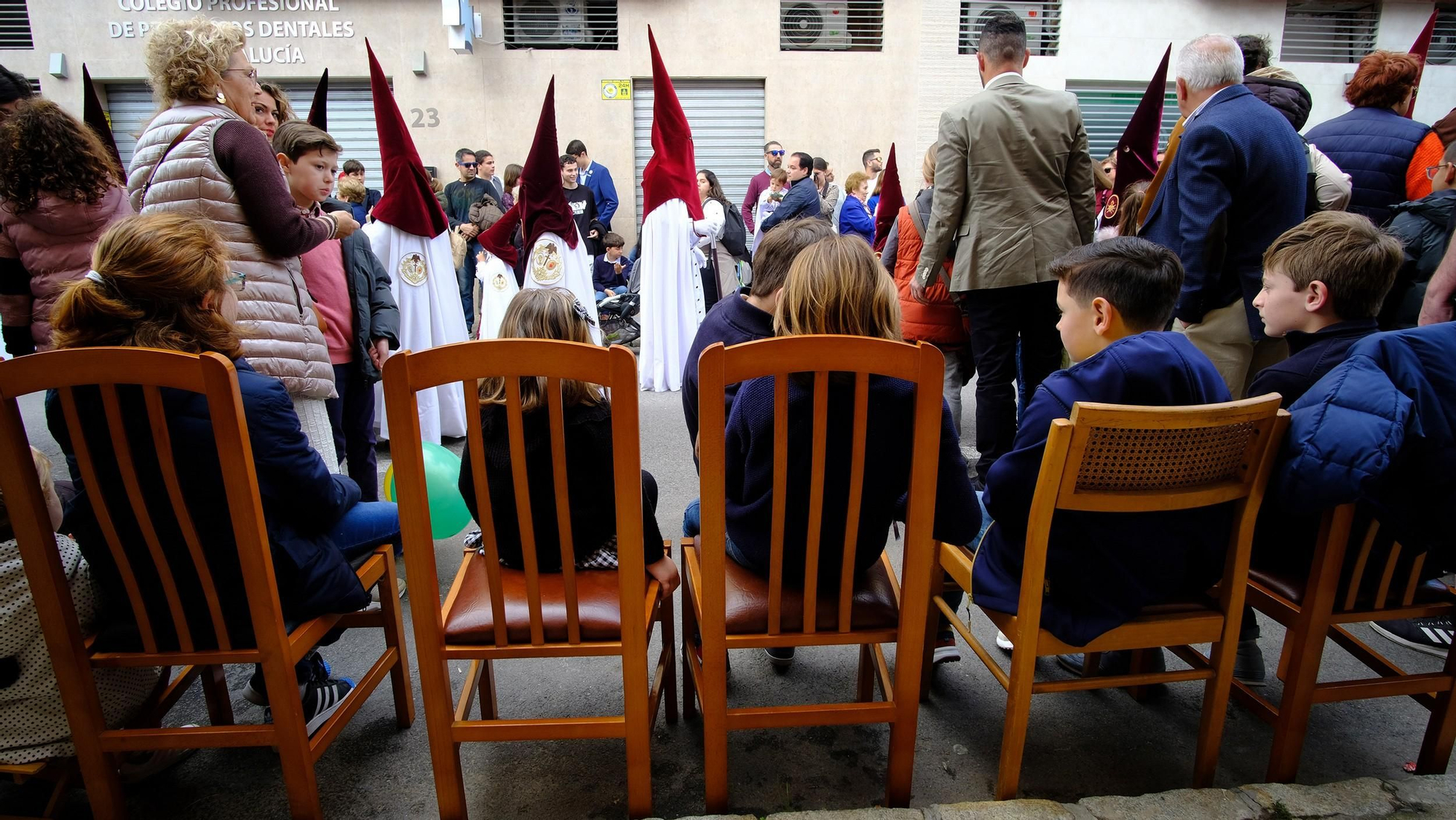 Las familias sacan sillas a la calle al paso de la cofradía de su barrio, la hermandad del Cerro (calle Aragón)