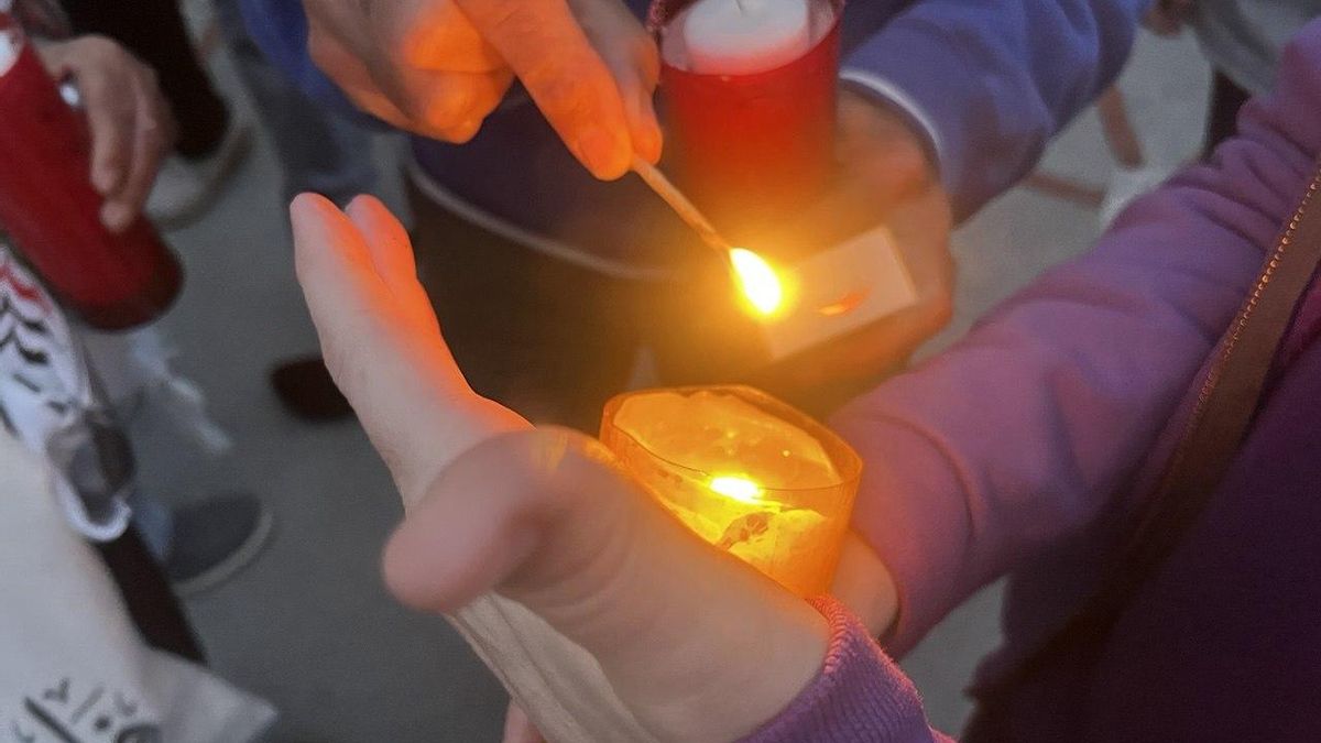 Un grupo de asistentes intentan que no se apague la llama.