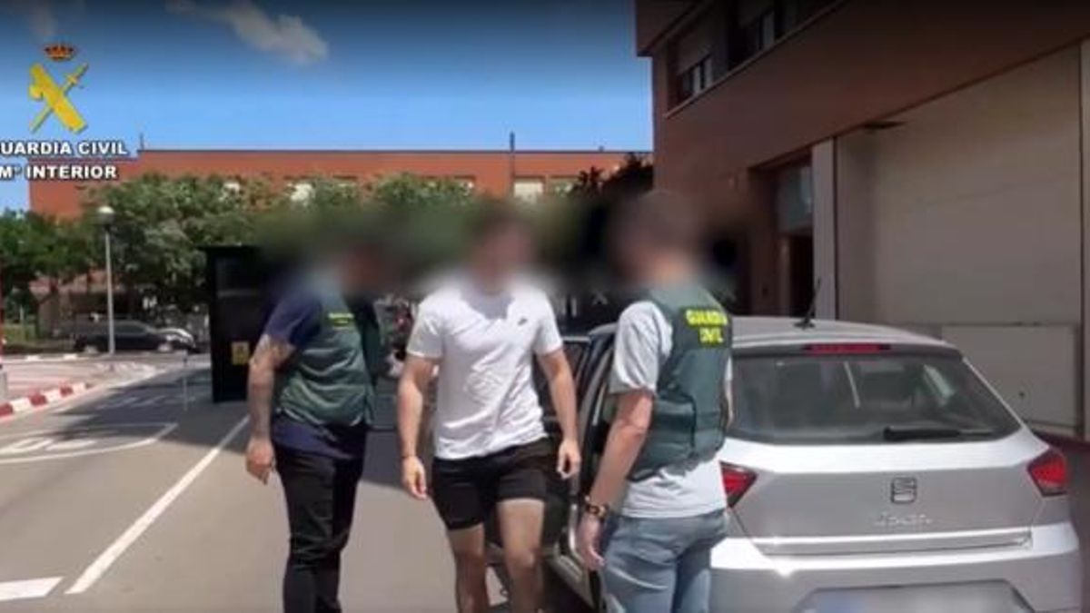 Dos agentes de la Guardia Civil escoltan a uno de los detenidos.