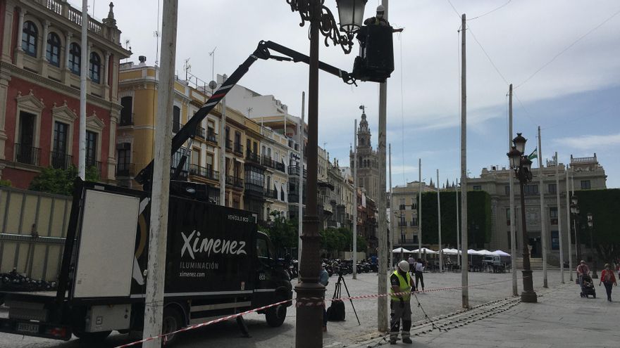 Operarios colocando las bombillas que recrearán en la plaza de San Francisco la decoración del Real.