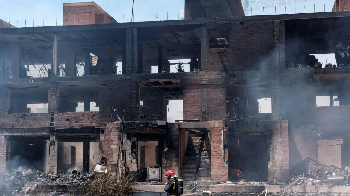 Un bombero trabaja en las labores de extinción del incendio con varias explosiones, originado en un edificio okupado del barrio de Es Viver de Eivissa.