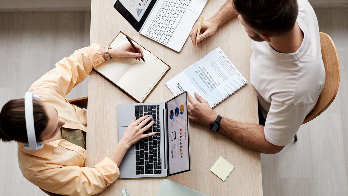 Dos personas compartiendo escritorio para trabajar