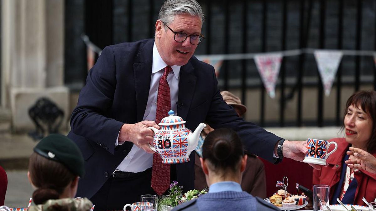 El primer ministro británico, Keir Starmer, sirve el té a veteranos en una fiesta en honor al 80 aniversario de la victoria de los aliados en la Segunda Guerra Mundial, el 5 de mayo delante de Downing Street, Londres.