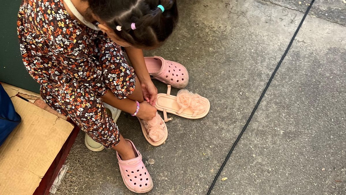 Una niña se pone sus "zapatos más bonitos" para el traslado al nuevo campamento estatal.
