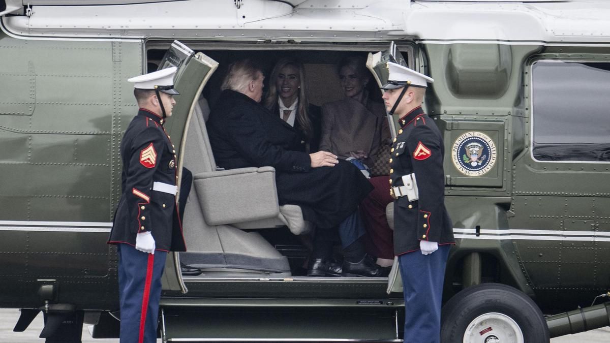 El presidente de Estados Unidos, Donald Trump, habla con la secretaria de prensa de la Casa Blanca, Katie Zacharia, y con su asesora, Natalie Harp, tras subir al Marine One en la base aérea de Elmendorf, en Anchorage (Alaska), el 13 de octubre de 2026.
