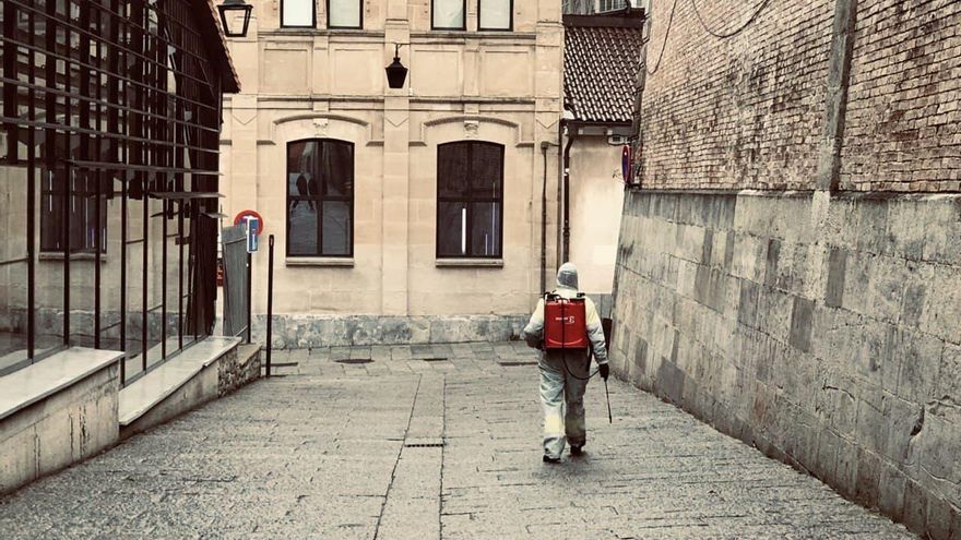 Un operario de limpieza desinfecta una calle vacía del centro de Vitoria en 2020