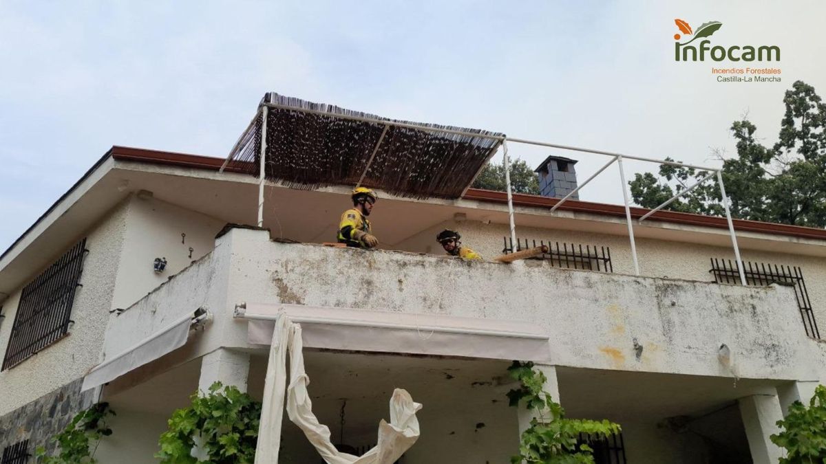 Bomberos forestales en Semillas quitando cortinas y otros enseres potencialmente inflamables de las viviendas