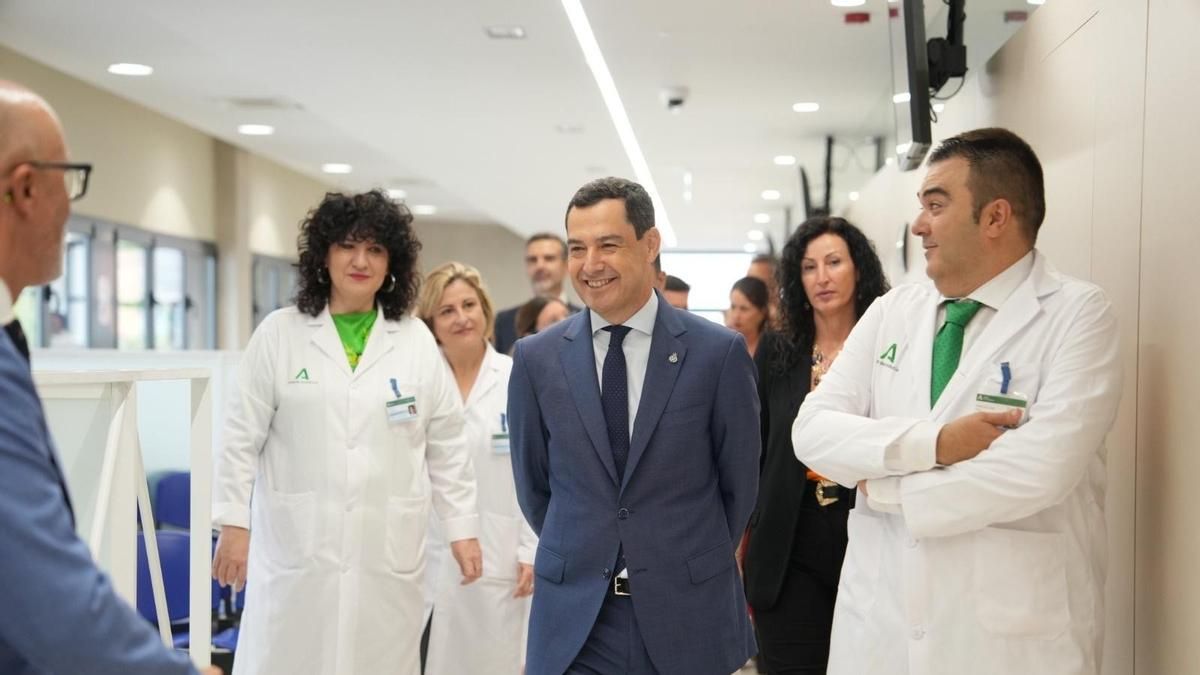 El presidente de la Junta de Andalucía, Juanma Moreno, durante la inauguración del nuevo consultorio de salud de Piedras Redondas en Almería, acompañado por profesionales sanitarios.