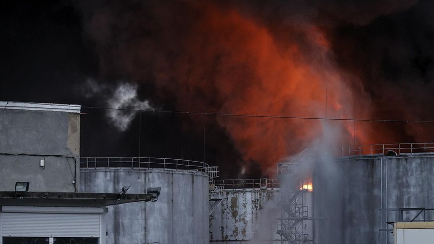 Tres columnas de humo se elevan en lugar donde se encuentra una refinería de petroleo en la ciudad ucrania de Odesa, después de que se escucharan fuertes explosiones sobre las seis de la mañana hora local. En la imagen los bomberos trabajan en la extinción del fuego.